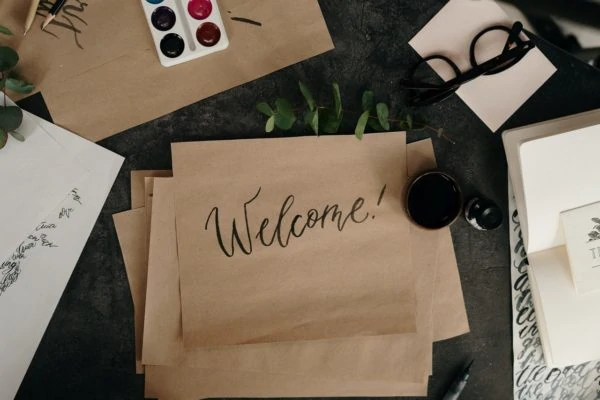brown paper with welcome written on it sitting on a desk